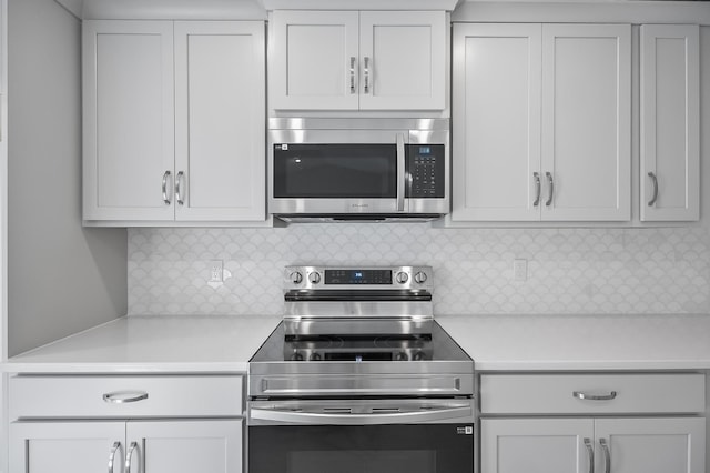 kitchen with white cabinetry, decorative backsplash, and appliances with stainless steel finishes