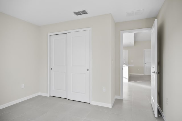 unfurnished bedroom featuring a closet and light tile patterned floors