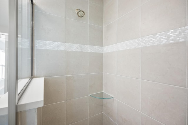 interior details featuring tiled shower