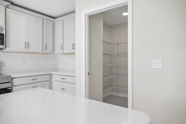 kitchen featuring tasteful backsplash and white cabinets