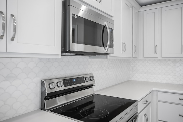 kitchen featuring white cabinetry, stainless steel appliances, and decorative backsplash