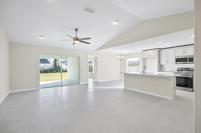 interior space featuring lofted ceiling, sink, ceiling fan with notable chandelier, and plenty of natural light