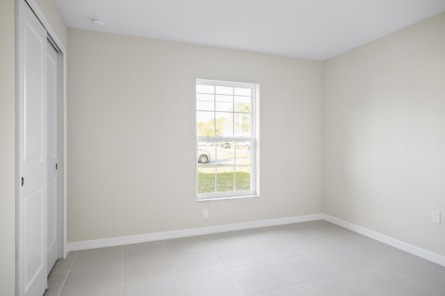 unfurnished bedroom with a closet and light tile patterned flooring