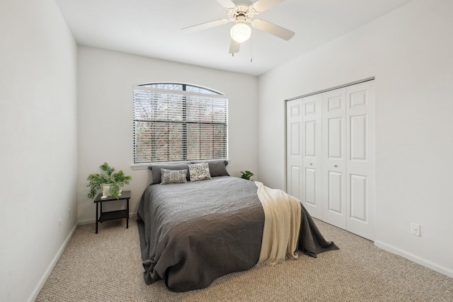 carpeted bedroom with a ceiling fan, a closet, and baseboards