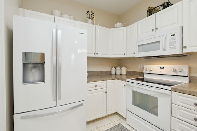 kitchen with light tile patterned floors, white appliances, and white cabinets