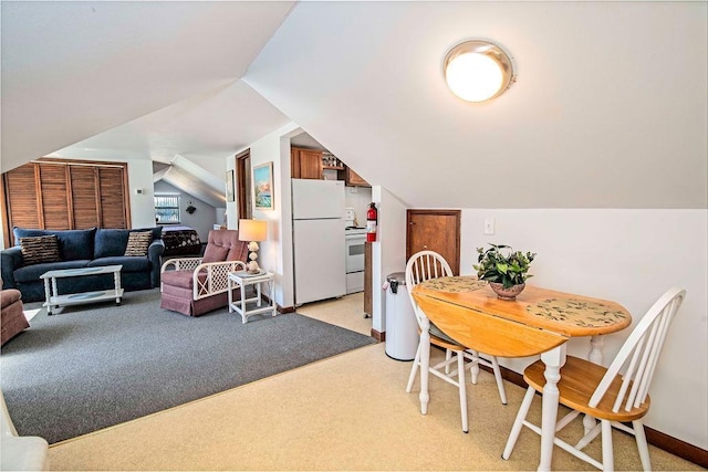 carpeted dining space featuring lofted ceiling