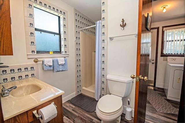 bathroom featuring washer / clothes dryer, hardwood / wood-style floors, a healthy amount of sunlight, and toilet