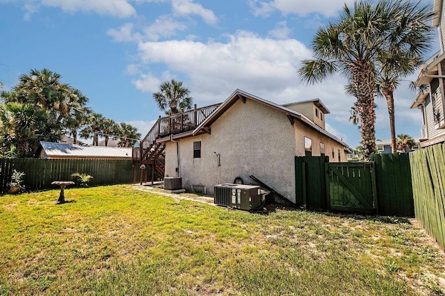 view of home's exterior featuring central air condition unit and a yard