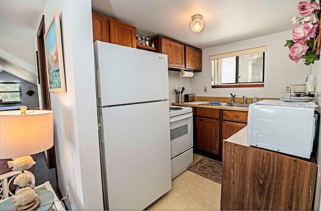 kitchen featuring white appliances, light colored carpet, and sink