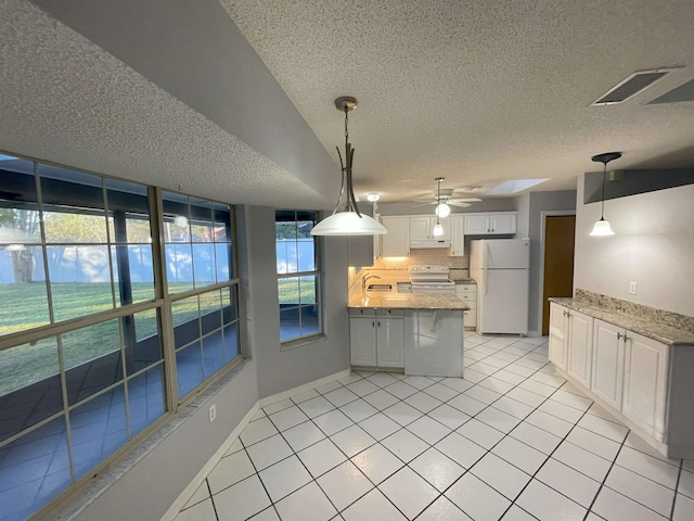 kitchen with white cabinetry, a textured ceiling, decorative light fixtures, white appliances, and light tile patterned floors