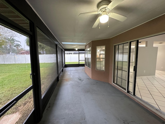 unfurnished sunroom featuring ceiling fan