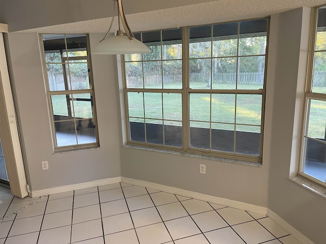 unfurnished room with tile patterned floors and a textured ceiling