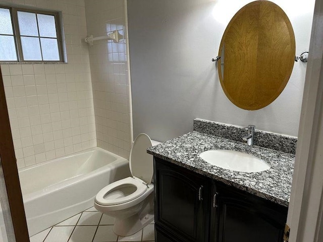 full bathroom featuring tile patterned floors, tiled shower / bath, vanity, and toilet