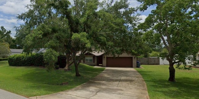 obstructed view of property featuring a garage and a front lawn