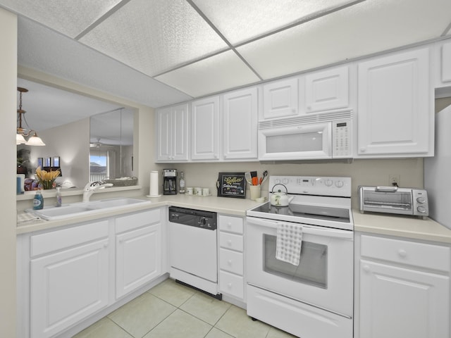 kitchen with white appliances, light tile patterned floors, light countertops, and a sink