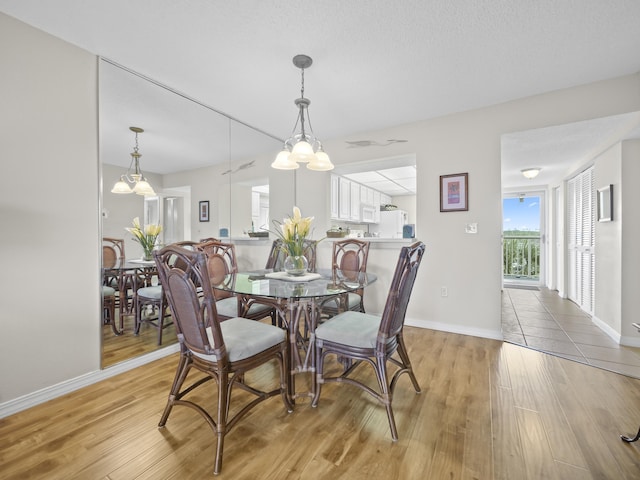 dining space featuring light wood-style floors and baseboards