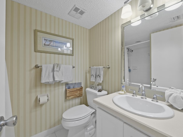 bathroom featuring visible vents, a textured ceiling, and wallpapered walls