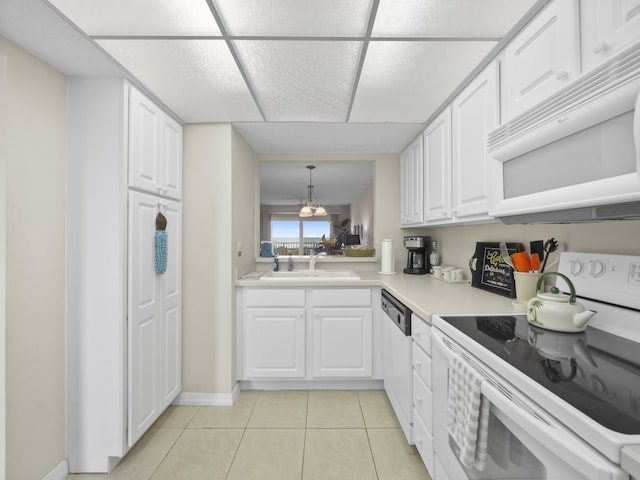 kitchen with light tile patterned floors, white cabinets, white appliances, and a sink