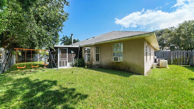 rear view of house with a lawn and a sunroom