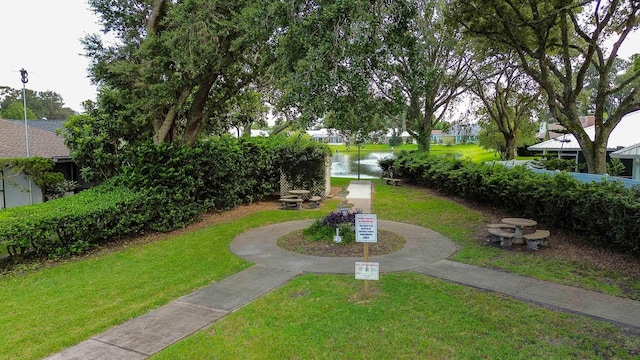 surrounding community featuring a lawn and a water view