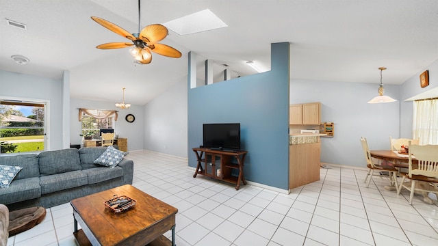 living room with ceiling fan with notable chandelier, a skylight, high vaulted ceiling, and light tile patterned flooring