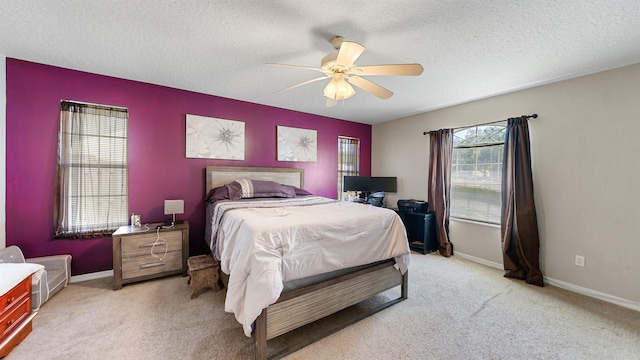 carpeted bedroom featuring a textured ceiling and ceiling fan