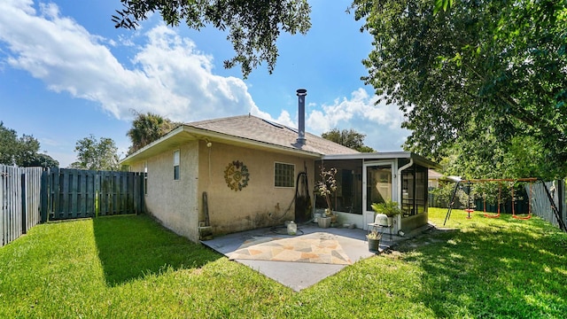 back of house featuring a yard and a sunroom