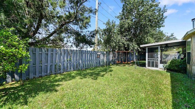 view of yard featuring a playground and a sunroom