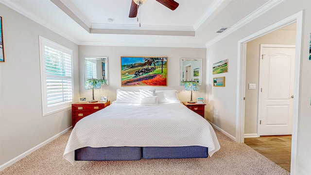 bedroom with hardwood / wood-style flooring, ceiling fan, ornamental molding, and a raised ceiling