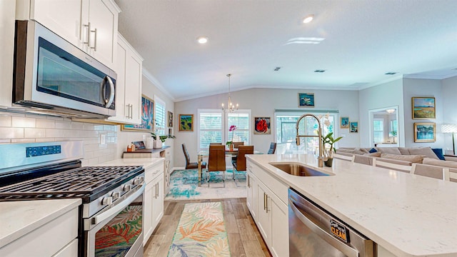 kitchen featuring a kitchen island with sink, sink, white cabinets, and appliances with stainless steel finishes