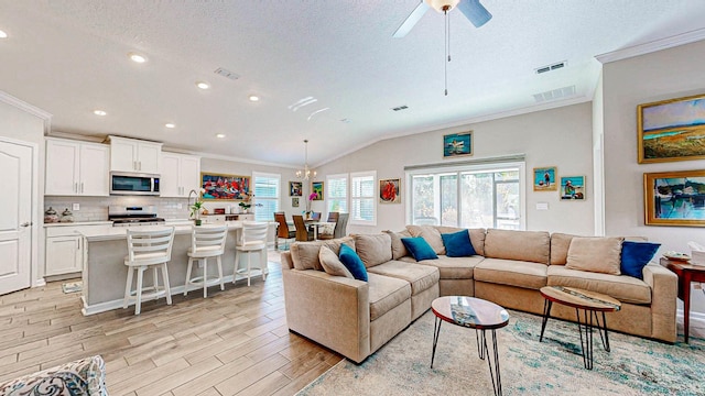 living room with crown molding, a wealth of natural light, and light hardwood / wood-style floors