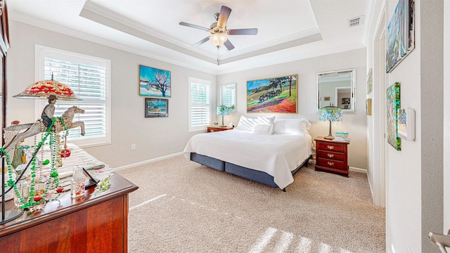 carpeted bedroom featuring crown molding, ceiling fan, and a raised ceiling