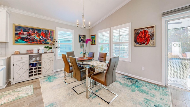 dining room featuring crown molding, lofted ceiling, a notable chandelier, and light hardwood / wood-style floors