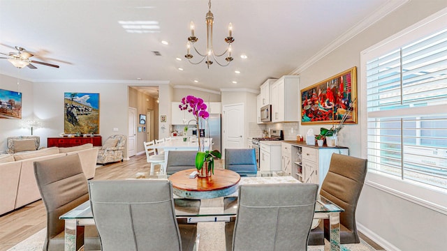 dining space featuring crown molding, ceiling fan with notable chandelier, and light hardwood / wood-style floors