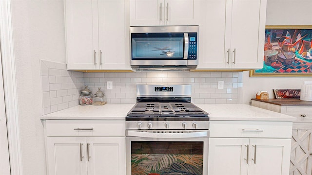 kitchen featuring light stone counters, white cabinetry, decorative backsplash, and appliances with stainless steel finishes