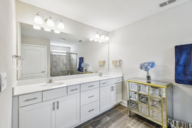 100 Dove Tree Ln, Saint Augustine, FL 32095 - full bathroom featuring double vanity, a stall shower, wood tiled floors, and a textured ceiling