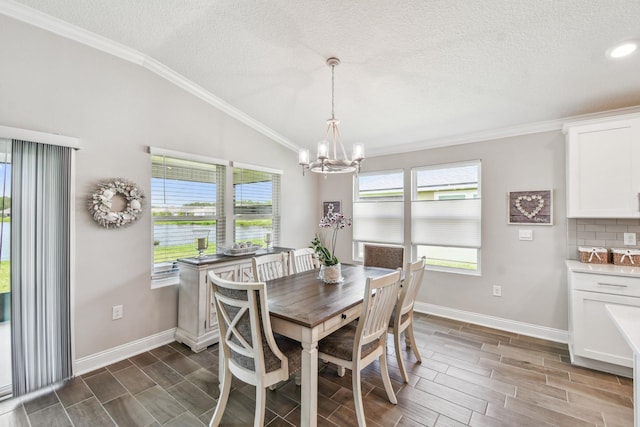 100 Dove Tree Ln, Saint Augustine, FL 32095 - dining area featuring lofted ceiling, crown molding, a chandelier, wood tiled floors, and healthy amount of natural light