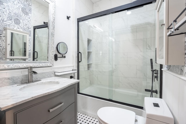 full bathroom with enclosed tub / shower combo, toilet, and vanity