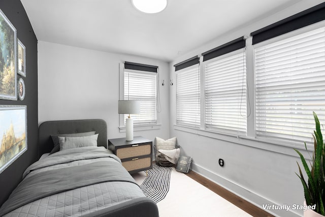 bedroom featuring baseboards and wood finished floors
