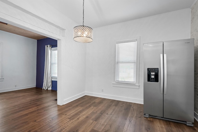unfurnished dining area featuring baseboards and dark wood-style flooring