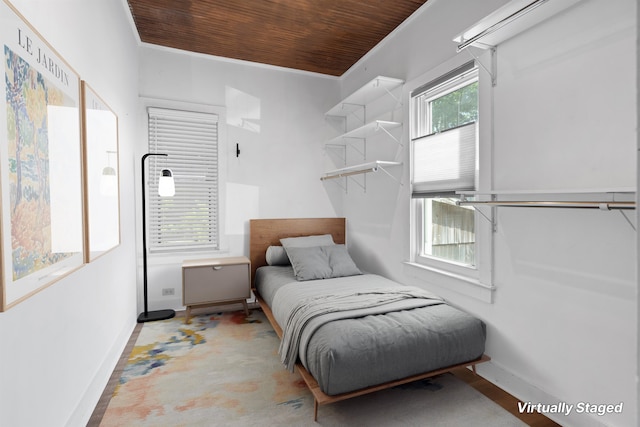 bedroom featuring wood ceiling, concrete floors, and baseboards