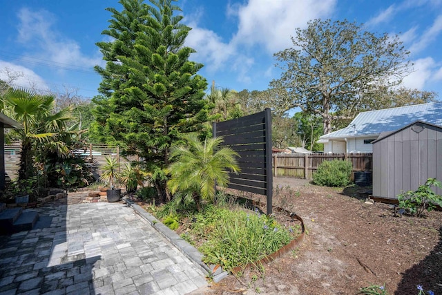 view of yard with an outdoor structure, a patio area, a shed, and a fenced backyard