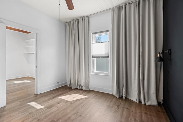 unfurnished bedroom with baseboards, a ceiling fan, and wood finished floors