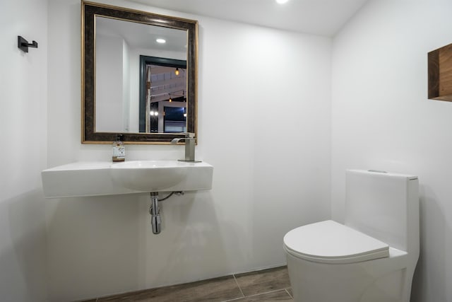 bathroom featuring wood finished floors, recessed lighting, and toilet