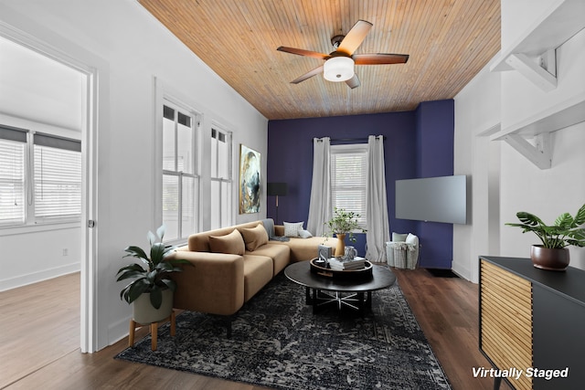 living area featuring dark wood-type flooring, baseboards, a ceiling fan, and wood ceiling