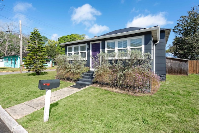 bi-level home featuring fence and a front lawn