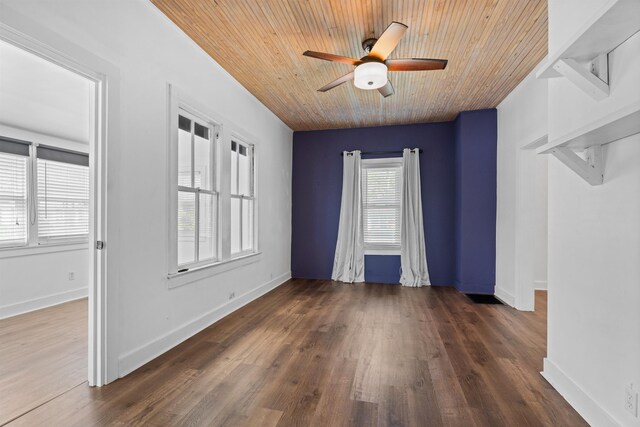 spare room featuring wooden ceiling, baseboards, a ceiling fan, and wood finished floors