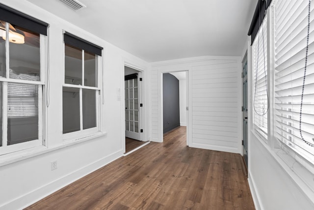 unfurnished room with wood finished floors and visible vents