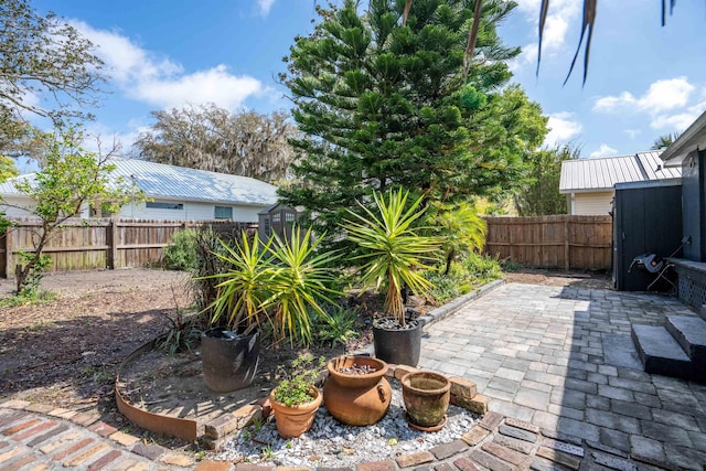 exterior space featuring a fenced backyard, an outbuilding, and a patio area