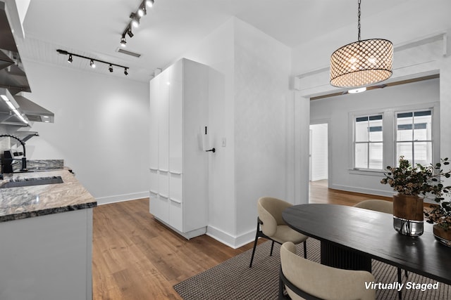 kitchen featuring open shelves, light wood-type flooring, baseboards, and a sink